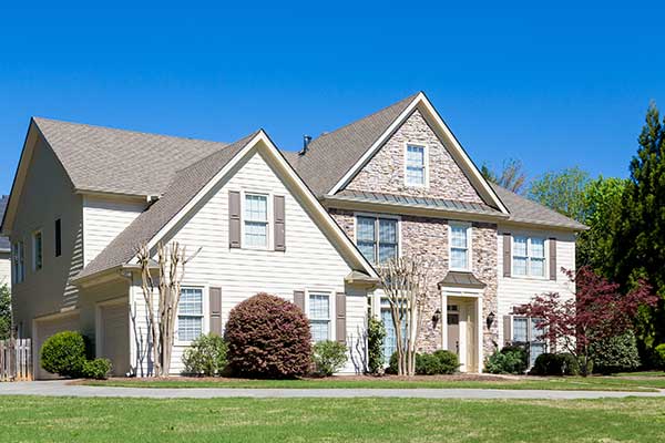 Front view of a typical mid-class home with a light brown shingle roof